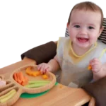 Bebê desenvolvendo autonomia durante a introdução alimentar.